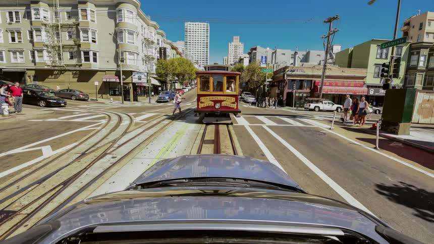 Time lapse of traffic and a trolley running the rail towards the large city