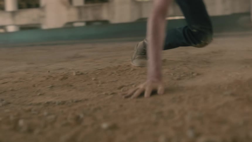 A man is dancing around in the dirt