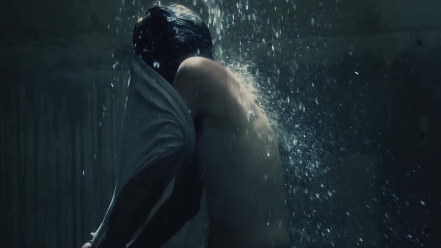 A man is getting rained on in a room