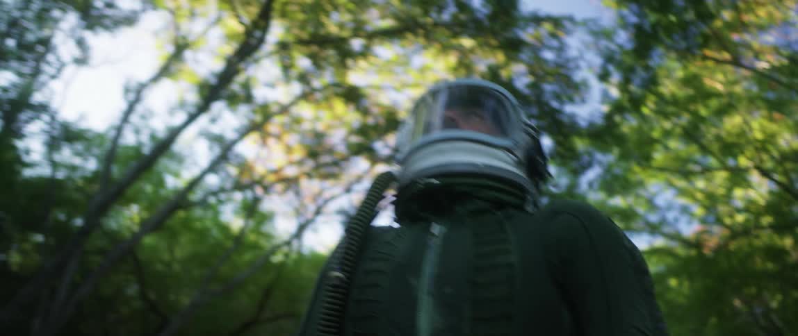 A man is walking outdoors in spring and wearing a helmet