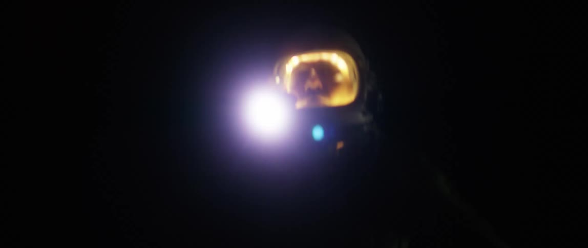 A person wearing space helmet is running while holding a torch