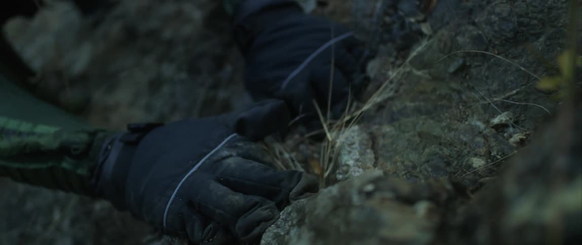 A person is crawling on the ground and wearing a helmet