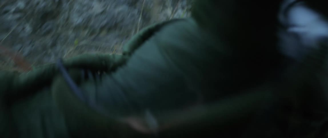 A man in a cosmonaut suit and helmet slips and tumbles down a steep rocky slope