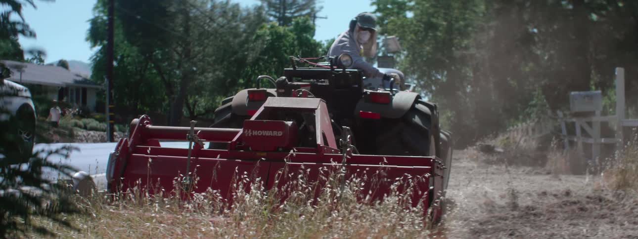 A person is driving a tractor in a rural area