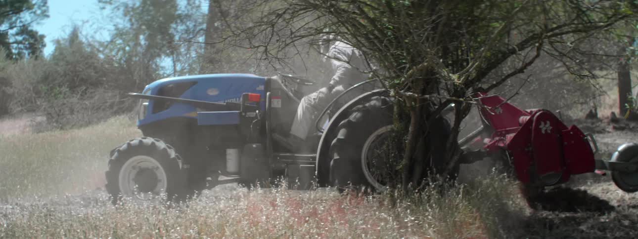 A man is driving a tractor in a rural area