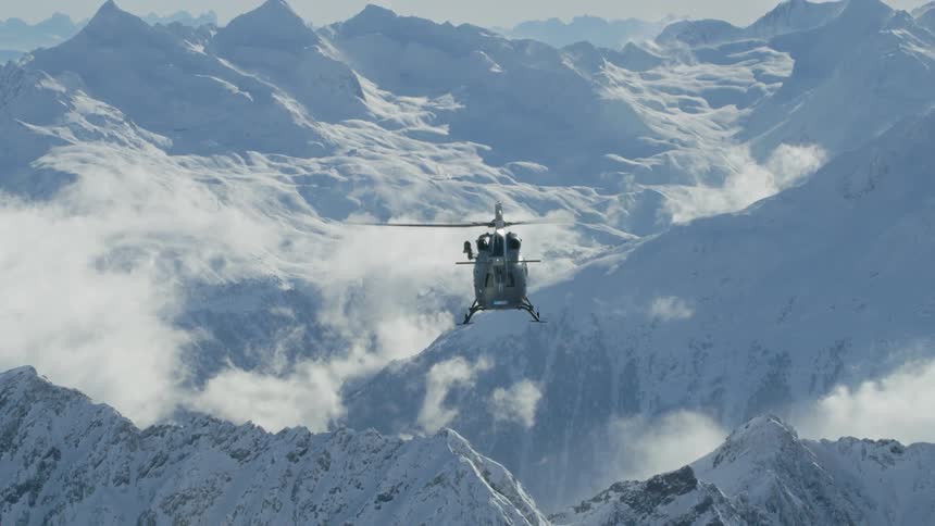 A view of a helicopter flying above a mountain range