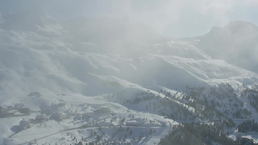 An aerial view of a mountain range with snow on it