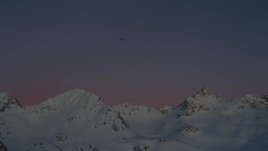 A view of a helicopter flying outdoors at dusk