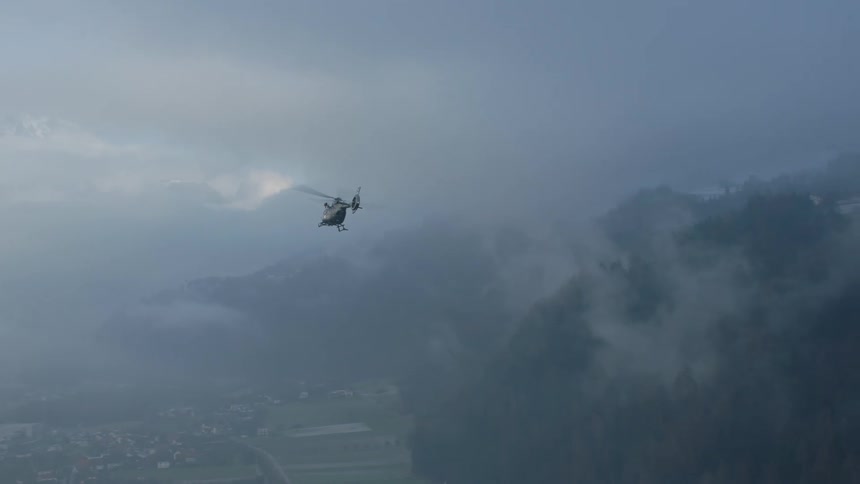 A view of a helicopter flying over a mountain area