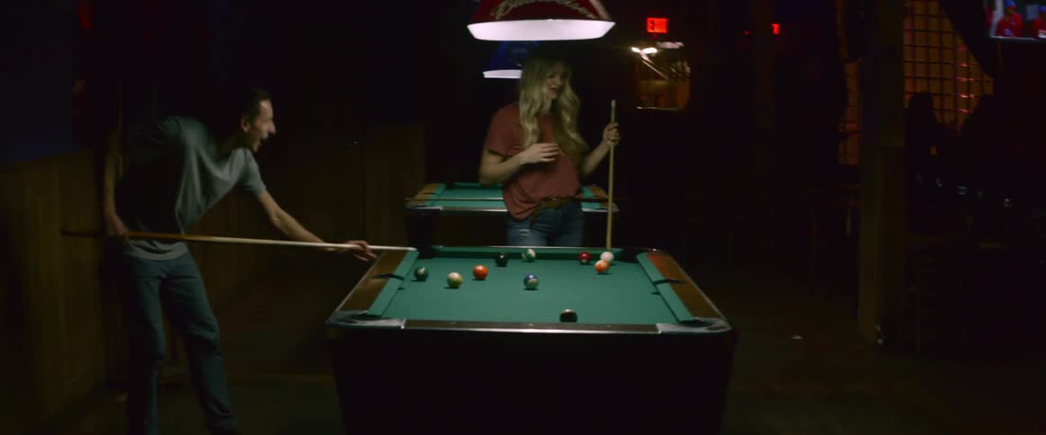 A man and woman playing pool