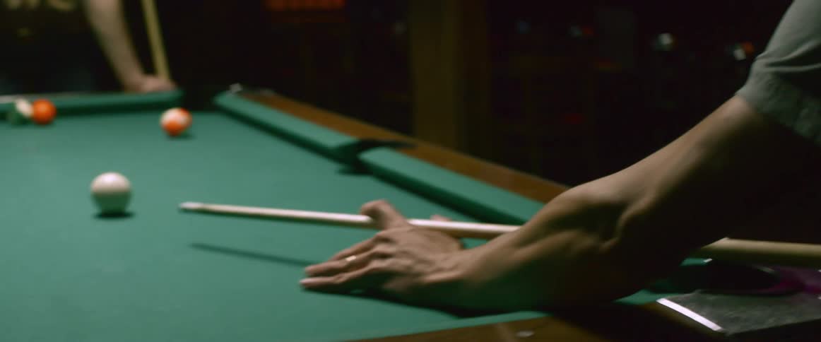 A man and woman are shooting pool