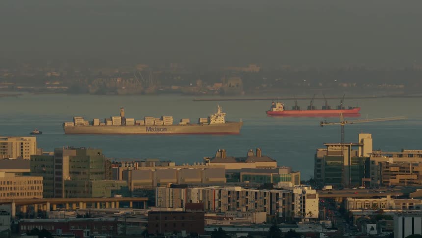 Large ships in a waterway next to a city
