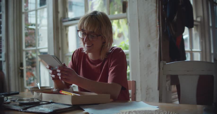 A woman looks at some items from a box