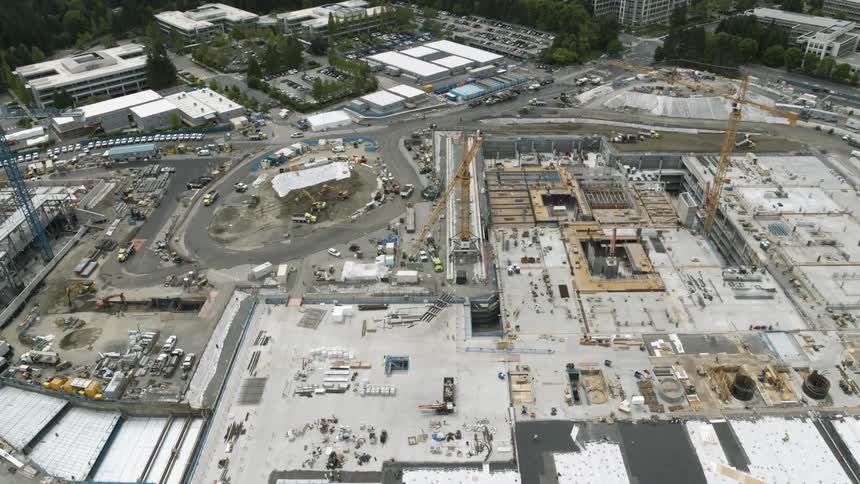 Tilt down aerial traverse above an enormous construction site complex