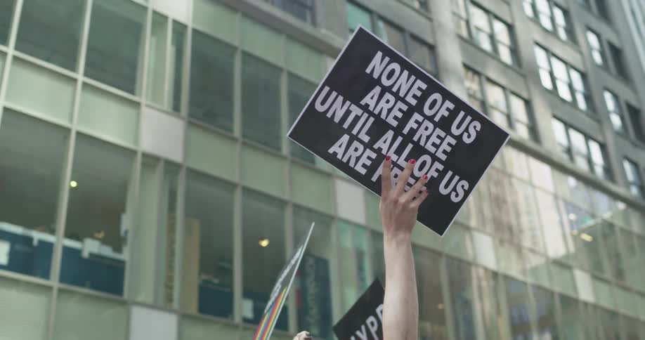 People are protesting in the city and holding signs