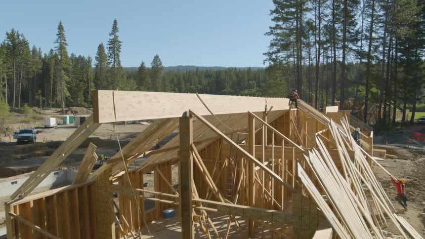Pullback reveal of wood framing and construction work at a new suburban development