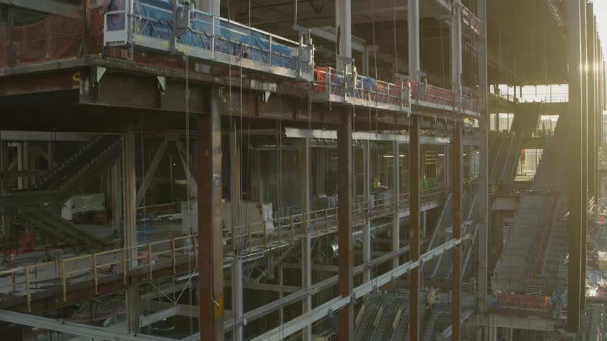 Ascending along the edge of a large multi floor building under construction