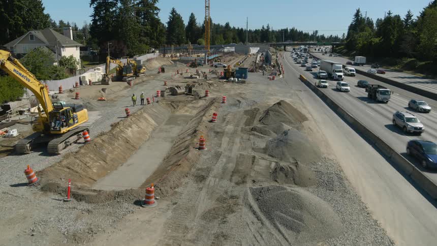 Low traverse over a public works construction site next to a busy highway