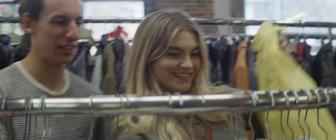 A man and women look through clothes in a store