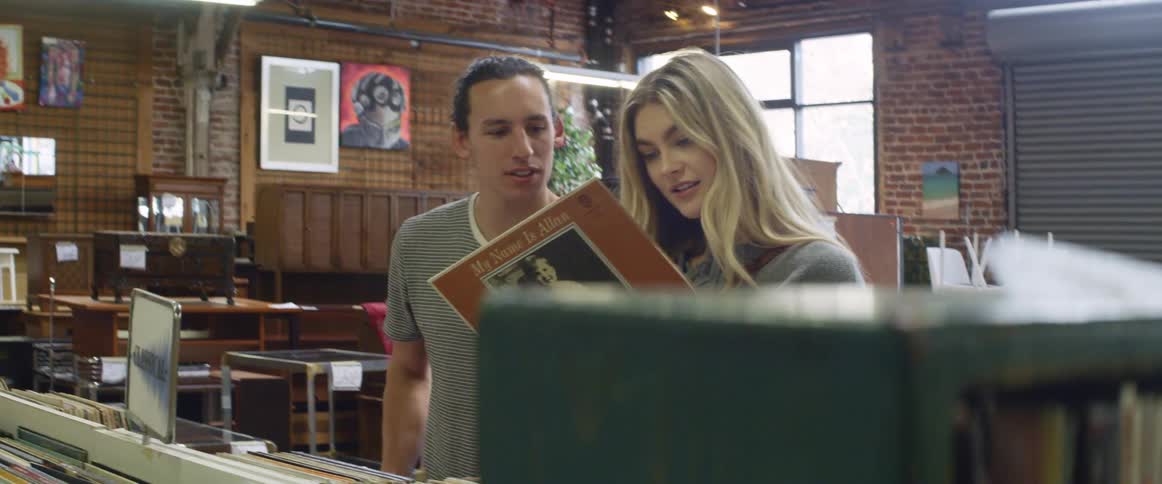 A man and woman look at records in a store