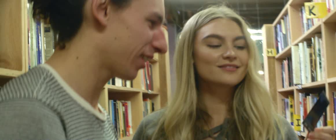 Two people in a library look at a photograph