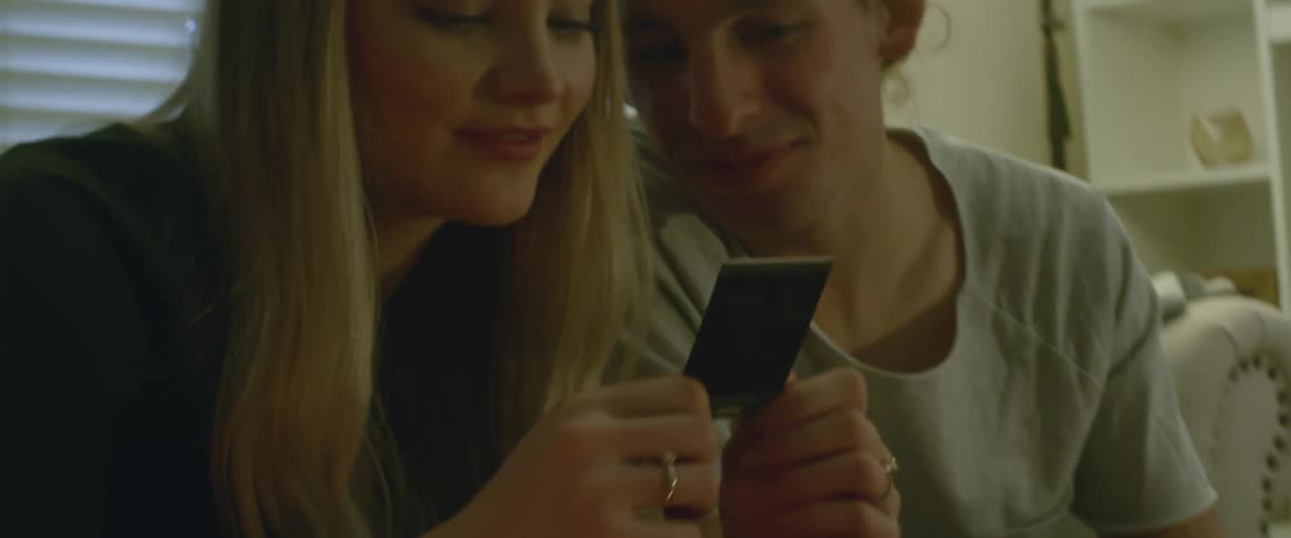 A man and woman look at photographs together
