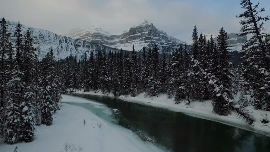 Aerial view moving down a cold snowy river