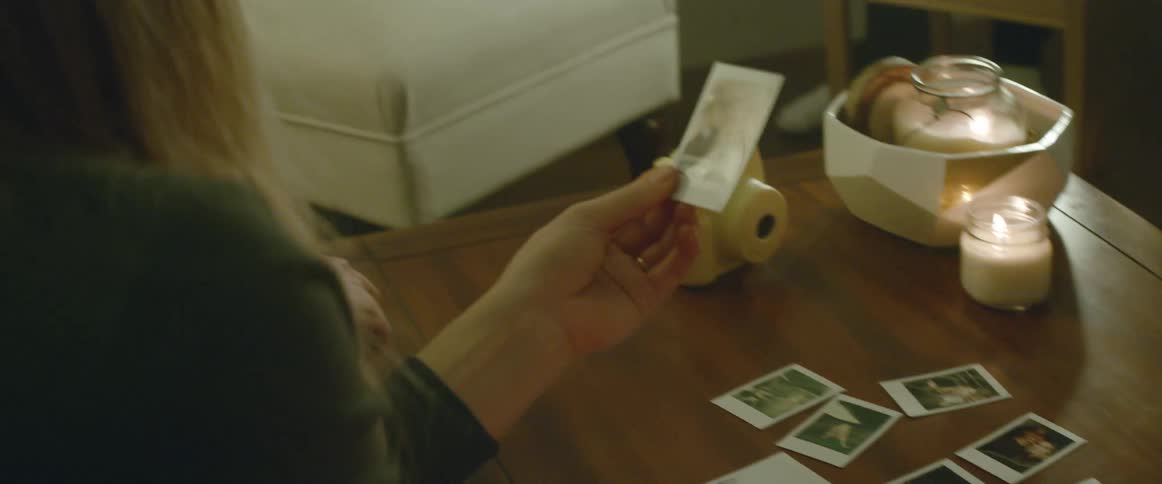 A woman picks up a picture from a table