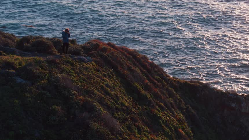 A man is standing on the edge of a cliff