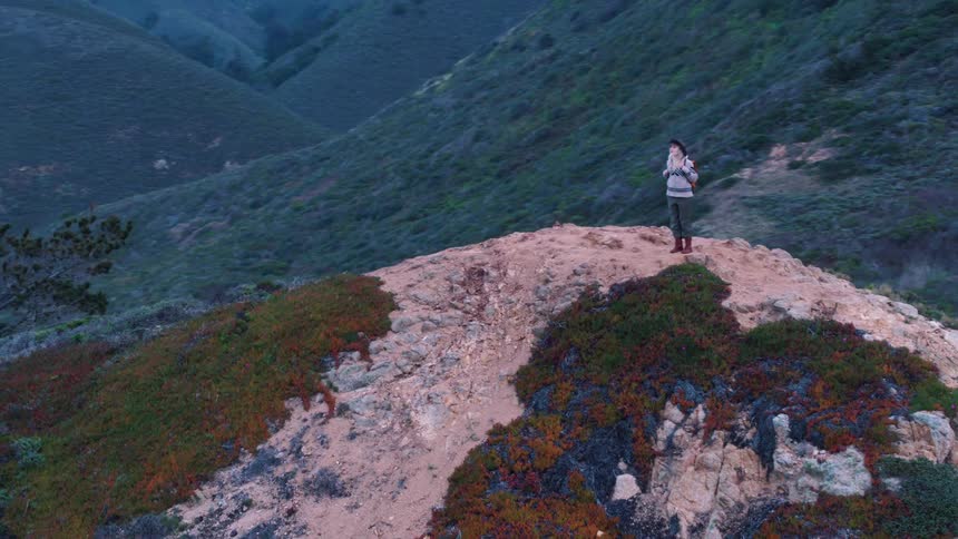 Woman standing on the top of a hill