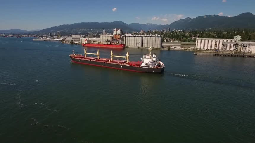 Red barge moving down a wide river