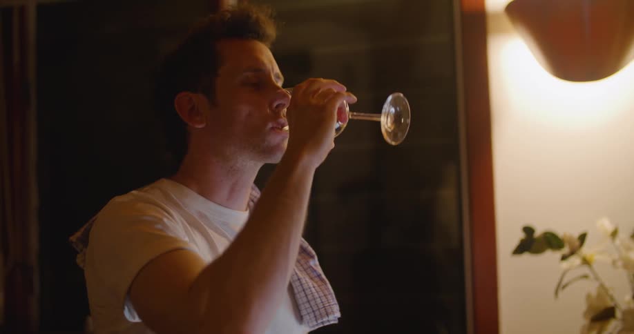A man drinking wine in a house