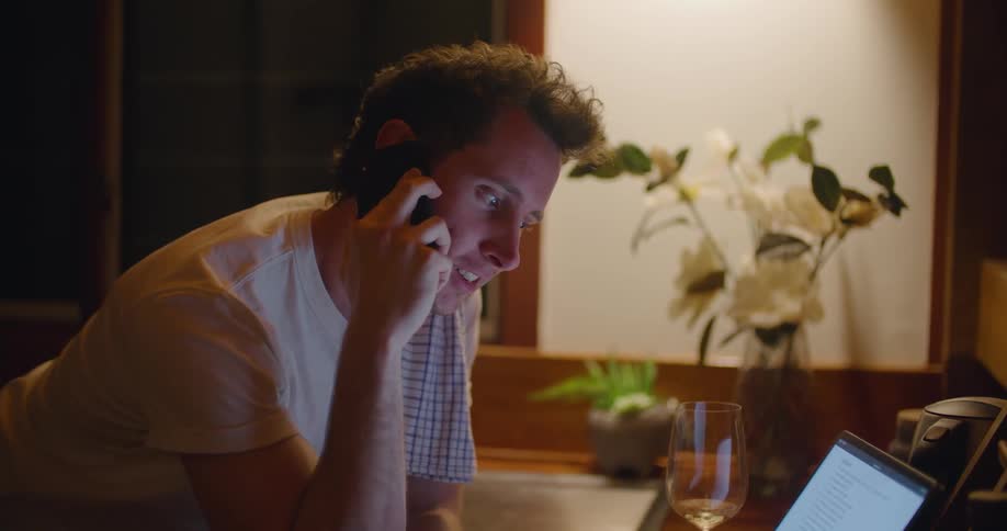 Man hangs up after talking on mobile phone before concentrating on tablet with attached keyboard
