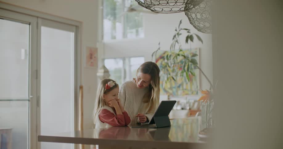 A mother and daughter looking at a tablet screen