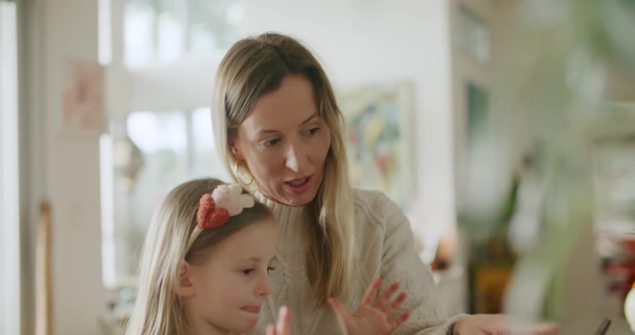 Mother wears sweater as she and daughter talk about tablet screen contents