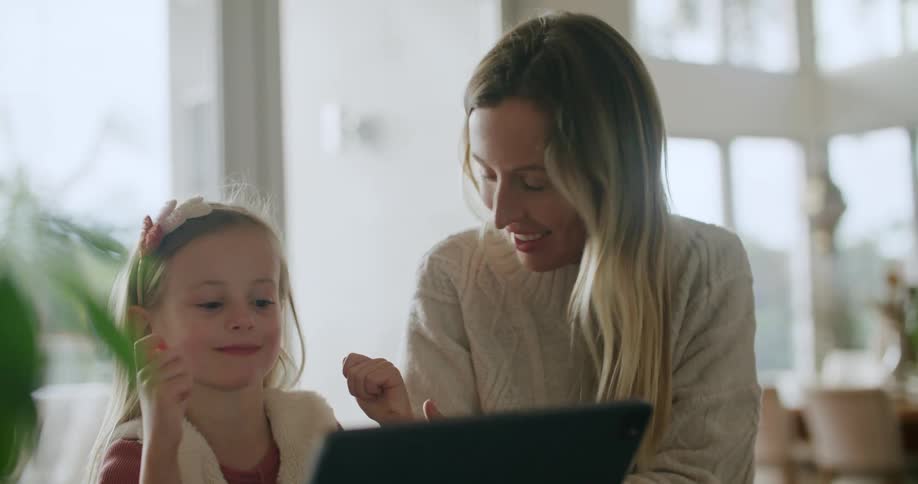 Mother and daughter using a touchscreen computer together at home