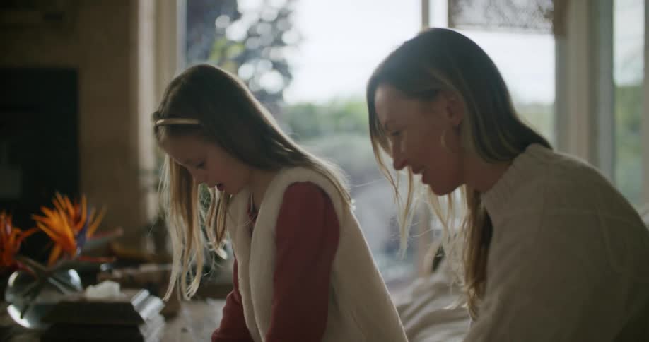 Mother and daughter solving a small puzzle at home