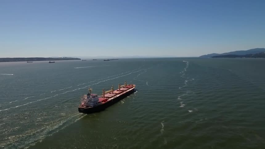 A large freight ship sails across the water