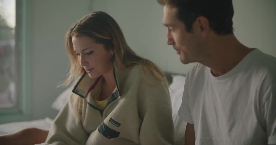 A man and woman sitting together writing and talking