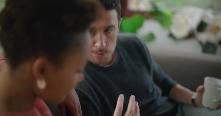 A man and woman sit together talking about a blue print on a tablet screen