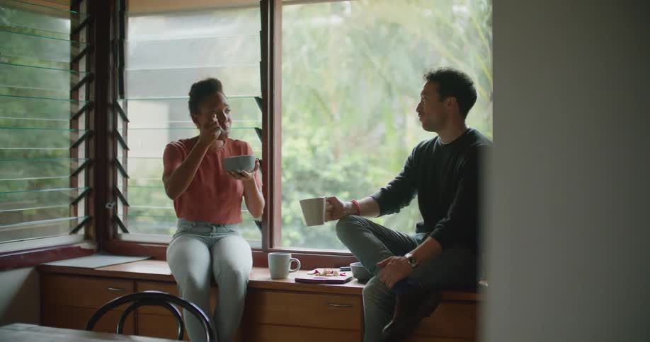 A man and woman talk and have a meal together in the kitchen