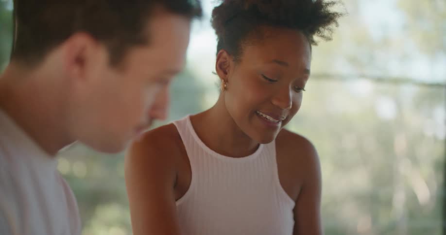 Young couple talking to each other in a room near the windows