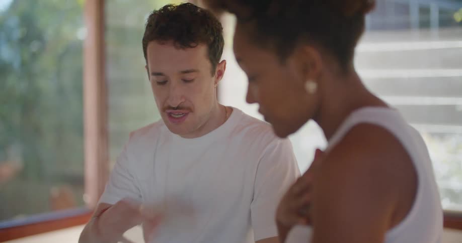 Woman teaching a man about physical exercise with a tablet