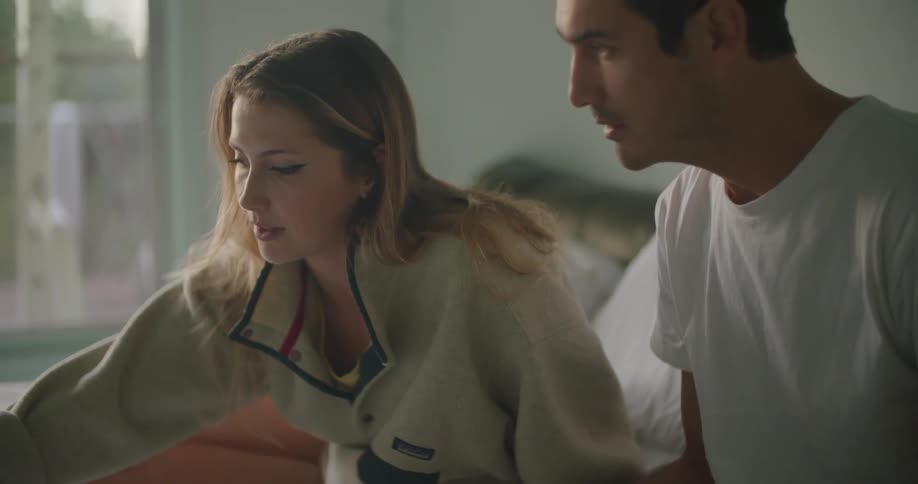 Young couple sitting in bed at morning working while eating breakfast