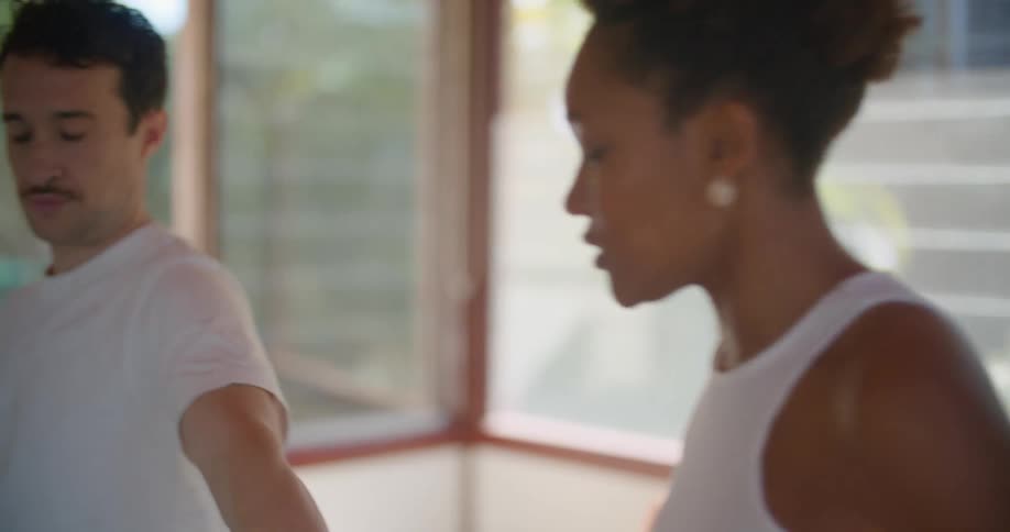 Fitness instructor teaching a man how to perform an exercise at home