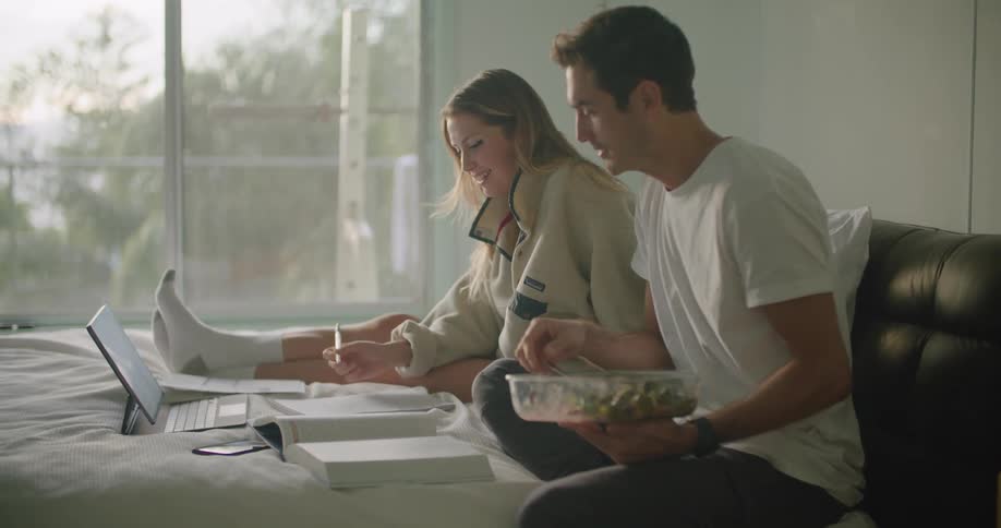 A man and woman sitting reading and talking
