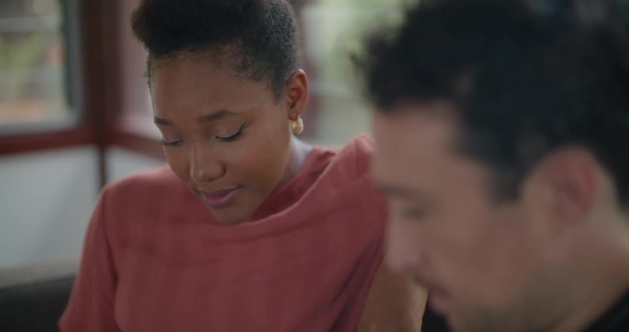 Man and woman sit discussing picture on tablet