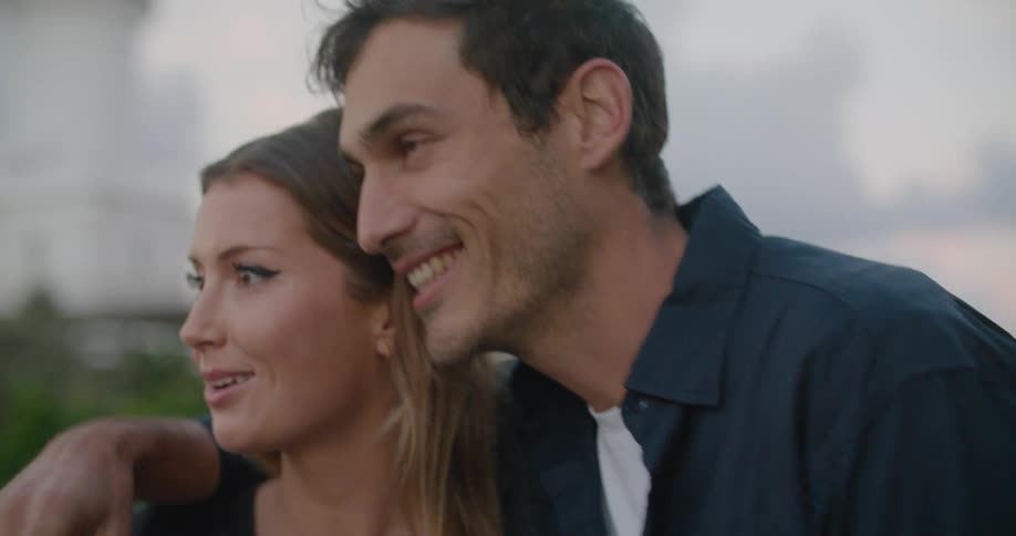 Man with a blue shirt puts hand on blonde womans shoulder and points at