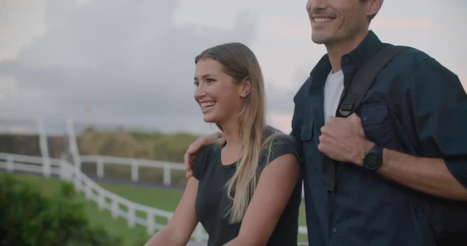 Man with a dark blue shirt puts his hand on blonde womans shoulder and laugh together