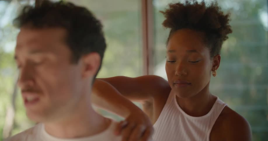 Woman wearing white massages shoulder of man